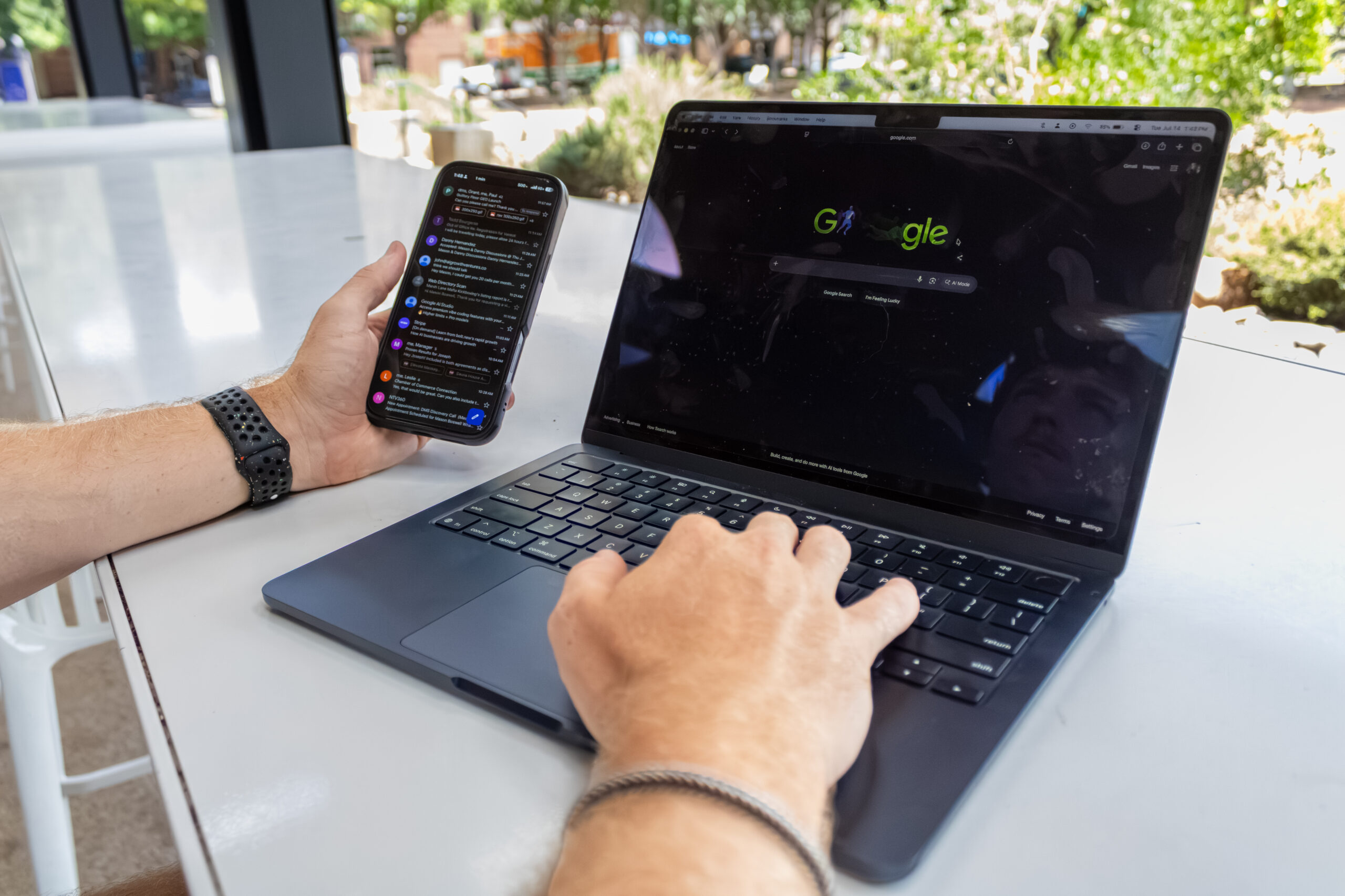 Person using a smartphone and laptop while working with Google search as part of a local digital marketing campaign.